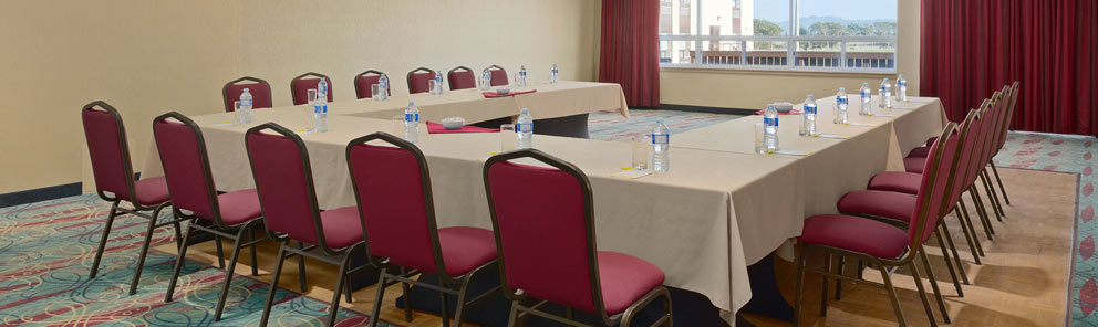 A spacious event room with tables set up in a U shape for a meeting at the Days Inn Stephenville hotel