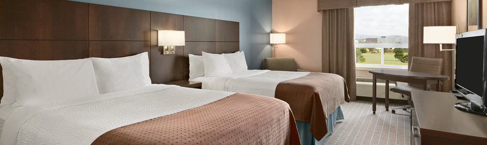 A double queen guestroom featuring modern lighting, two comfortable beds & more at the Days Inn Stephenville