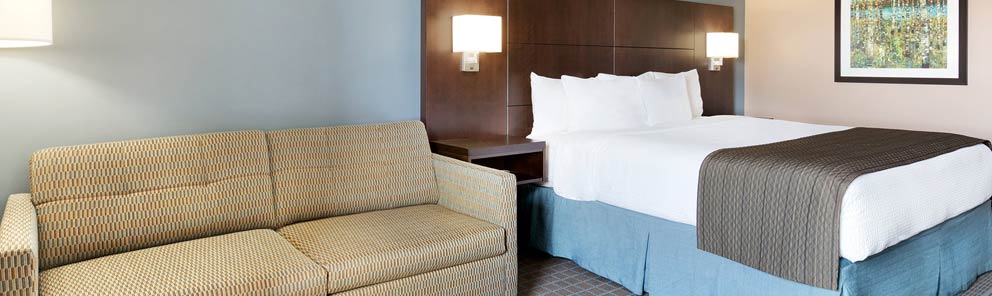 A suite at the Days Inn Stephenville featuring a large comfortable bed, pull out sofa bed & more